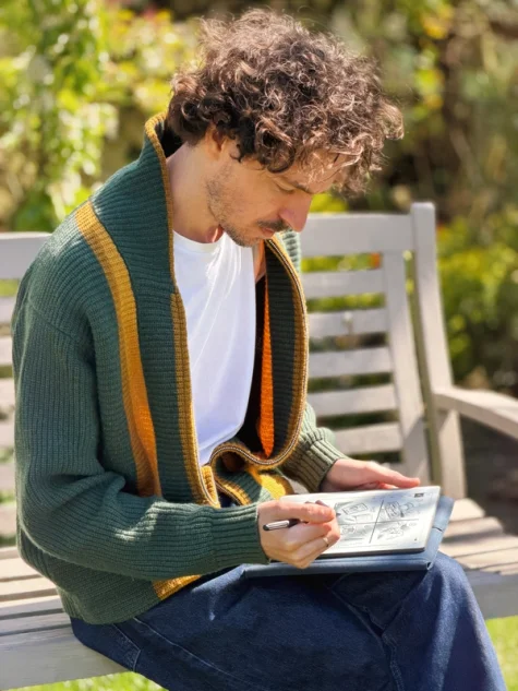 Jake Ogden sitting outside on a bench while sketching on his reMarkable Paper Pure tablet.