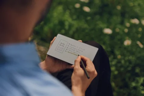 A reMarkable paper tablet showing a list, being marked with the Marker.