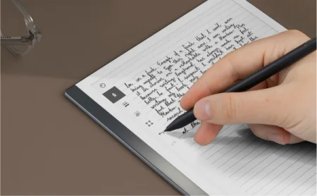 A reMarkable paper tablet with a hand tapping the undo button.