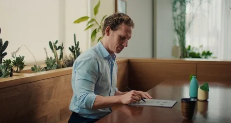 A man reviewing a document at a table with the reMarkable paper tablet.