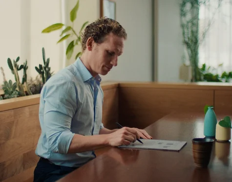 A man writing on a reMarkable paper tablet with the Marker.
