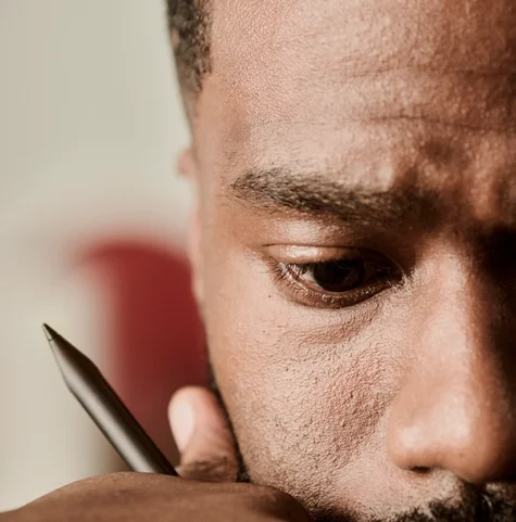 Person in deep thought holding a reMarkable Marker Plus