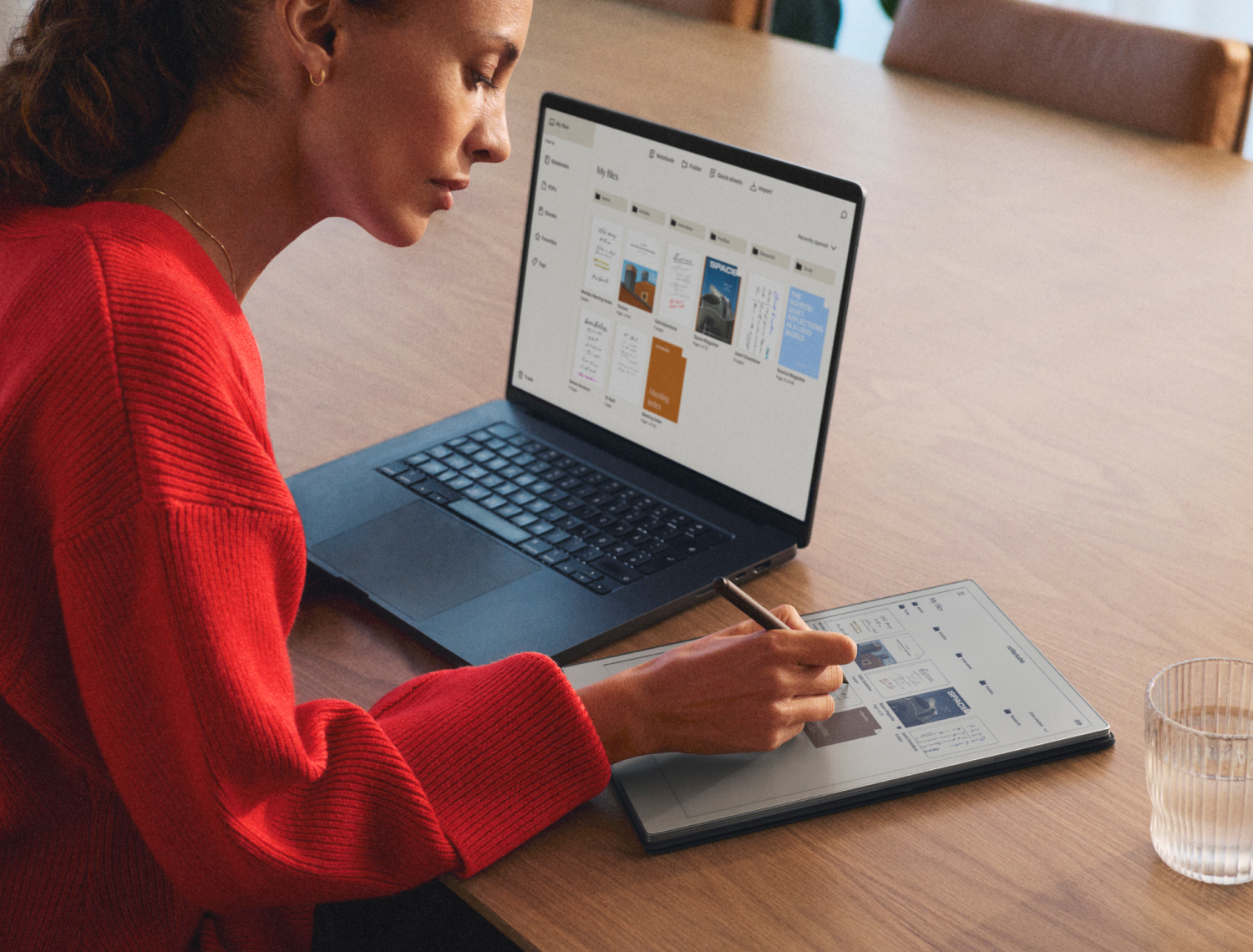 A person writing on a reMarkable Paper Pro, while using the reMarkable desktop app on her laptop for easy organizing.