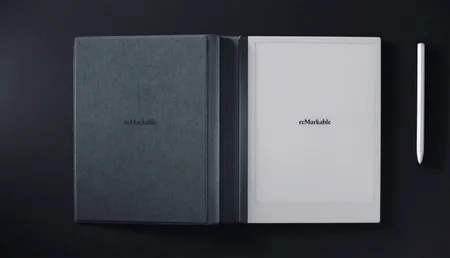 reMarkable paper tablet in Folio with Marker on black surface.