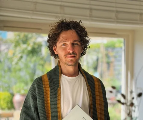 Jake Ogden standing while holding his reMarkable Paper Pure tablet.