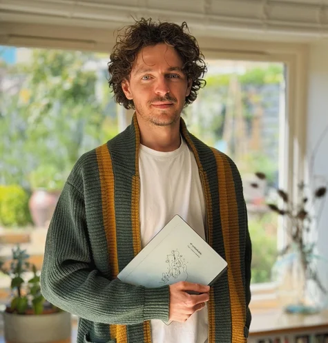 Jake Ogden standing while holding his reMarkable Paper Pure tablet.
