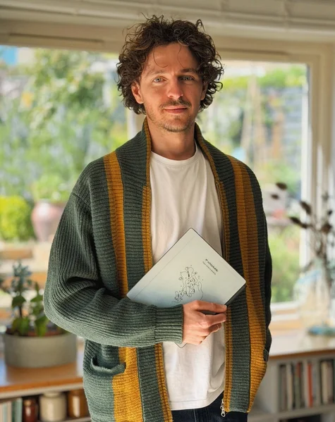 Jack Ogden standing while holding his reMarkable Paper Pure tablet.