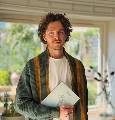 Jake Ogden standing while holding his reMarkable Paper Pure tablet.