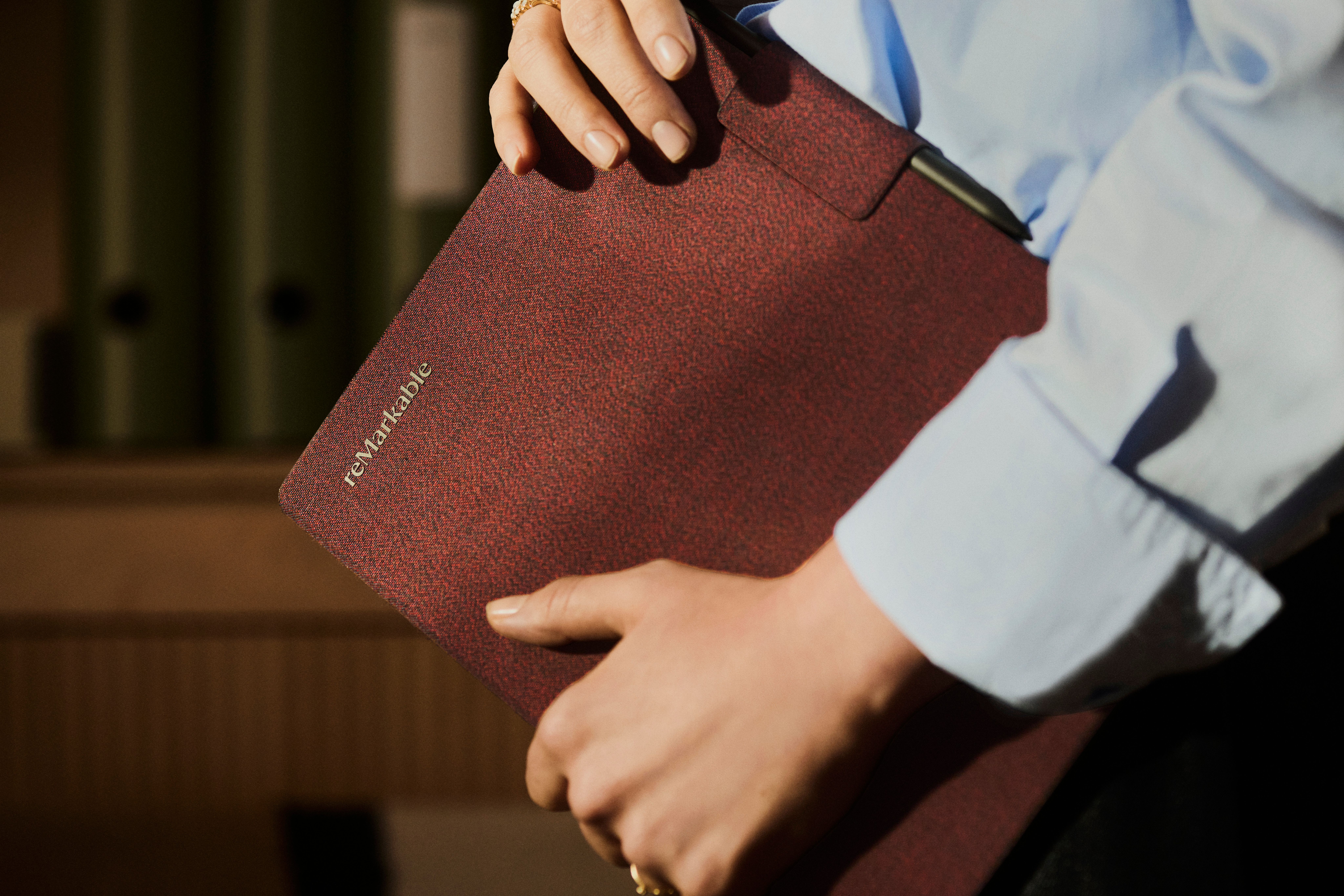 A man holding a reMarkable Paper Pro tablet with a burgundy Book Folio.