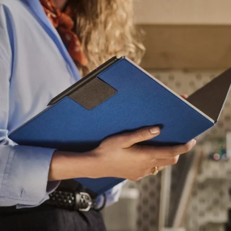 reMarkable Paper Pro tablet in a cobalt color Book Folio cover, held open.