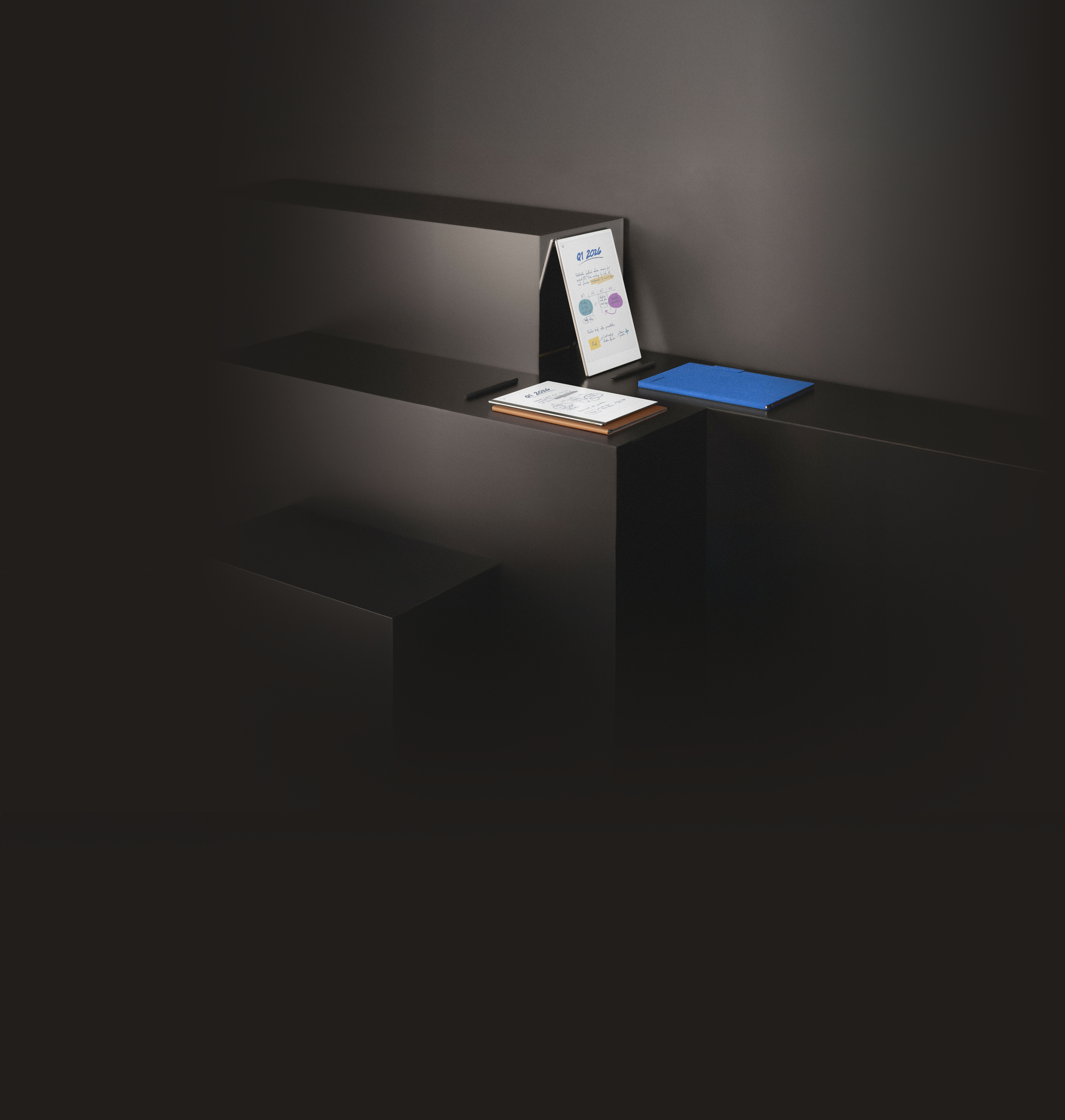 All reMarkable paper tablets, reMarkable 2, reMarkable Paper Pro and reMarkable Paper Pro Move resting on layered shelves.