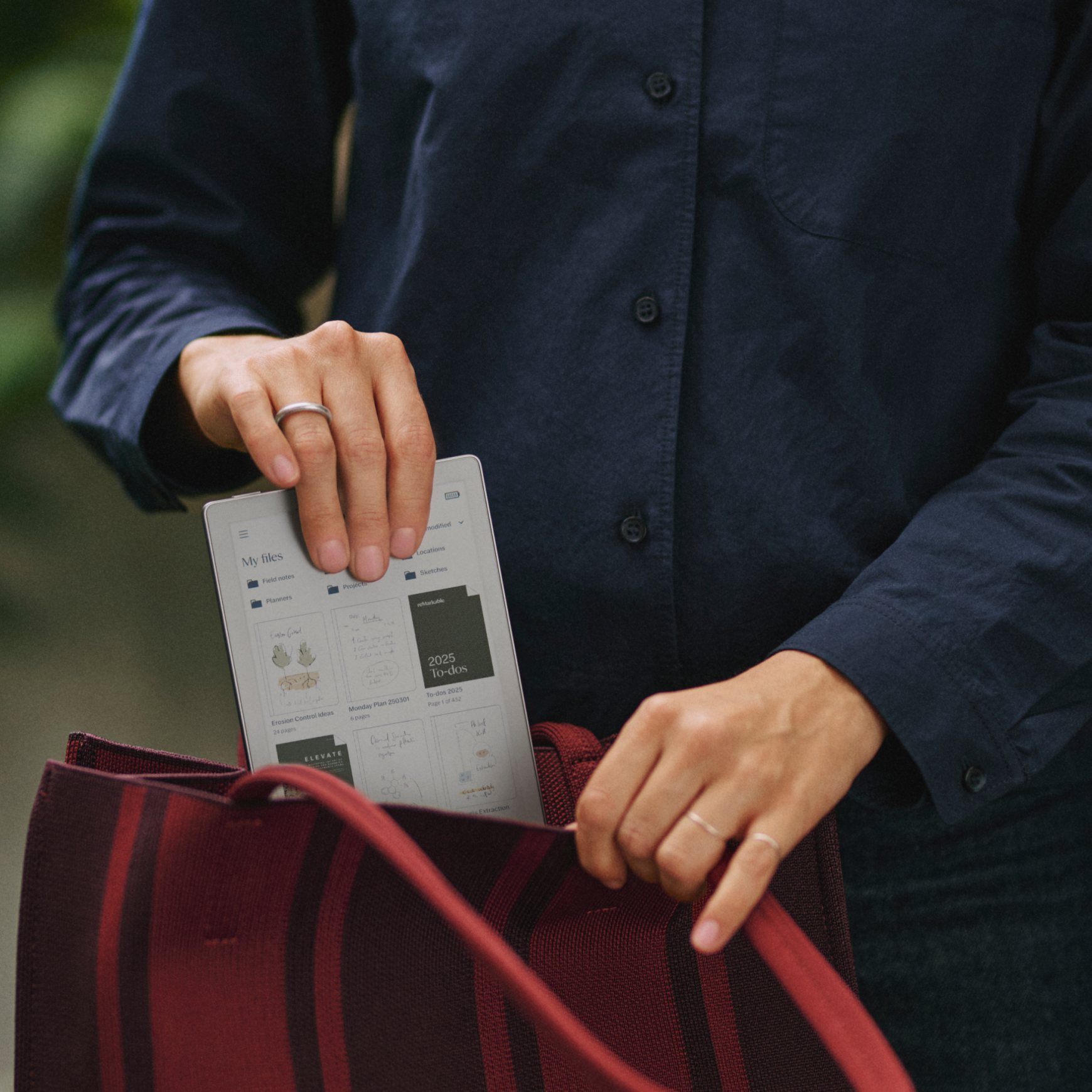 A reMarkable Paper Pro Move being placed in a purse, showing its portability.