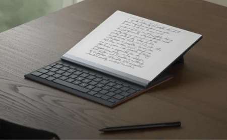 A reMarkable paper tablet with the Type Folio attached, with notes visible on the display, and a Marker nearby.