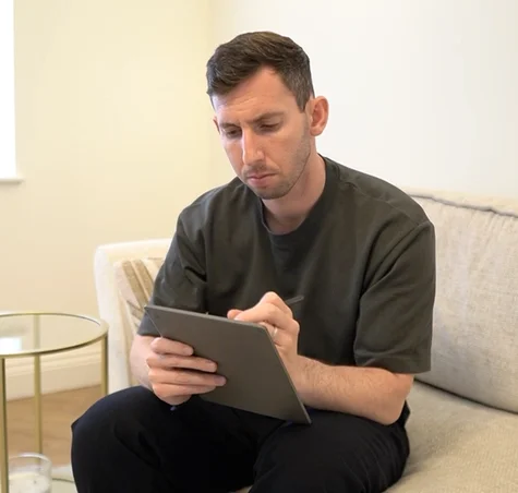Gabriel Nussbaum sitting on his couch working on his reMarkable Paper Pure tablet.