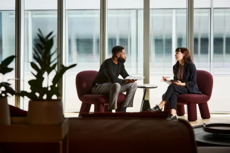 Two people sitting in chairs, talking.