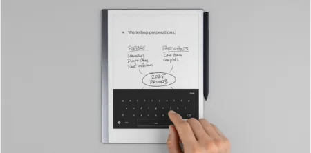 A reMarkable paper tablet displaying a on-screen keyboard with a finger touching the screen.