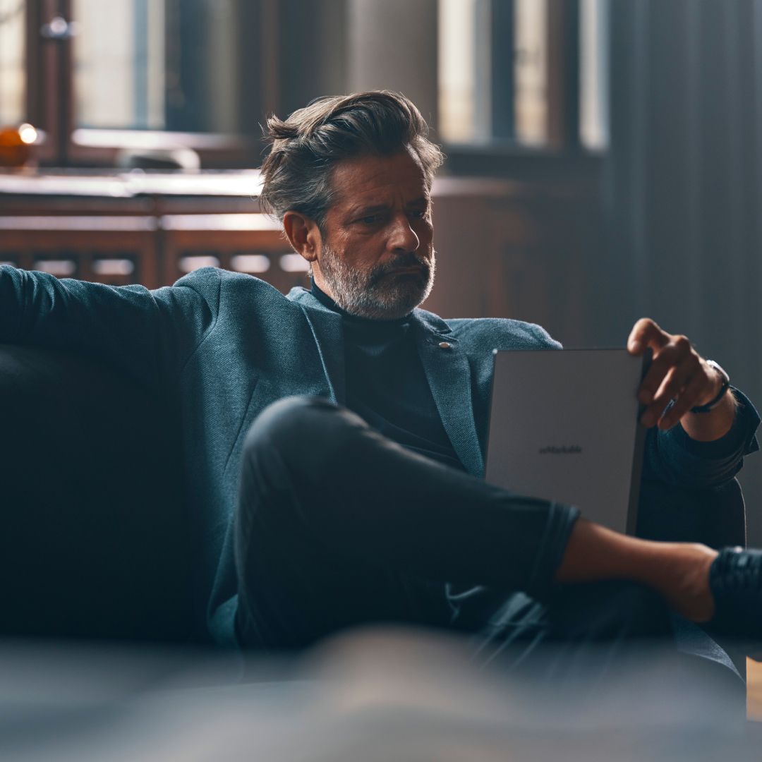 Man sitting on couch with reMarkable tablet