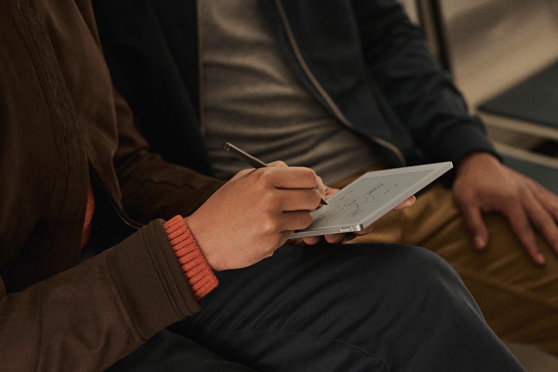 A reMarkable paper tablet with notes as someone writes with the Marker.