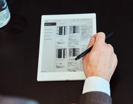 A reMarkable paper tablet displaying notes with a hand using the Marker.