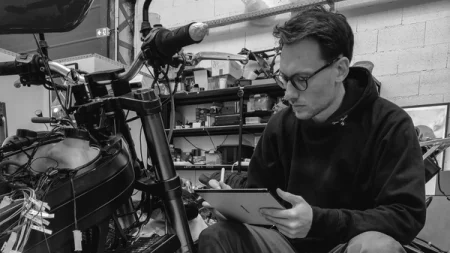 A man using a reMarkable paper tablet in a workshop setting.