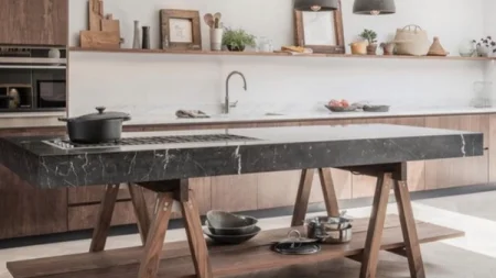 A modern kitchen island with a black pot on a built-in stovetop.