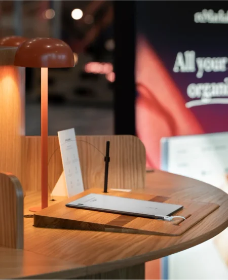 reMarkable paper tablet on a wooden desk with a lamp.