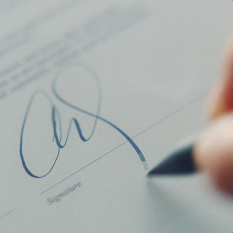 A close-up of a person signing a document on reMarkable Paper Pro with their Marker Plus.