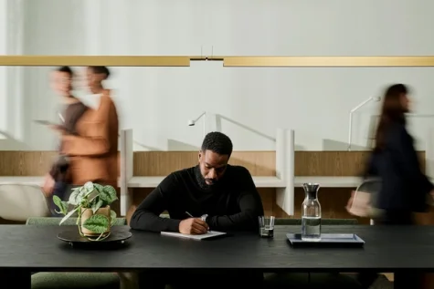 A man writing on a notepad at a table.