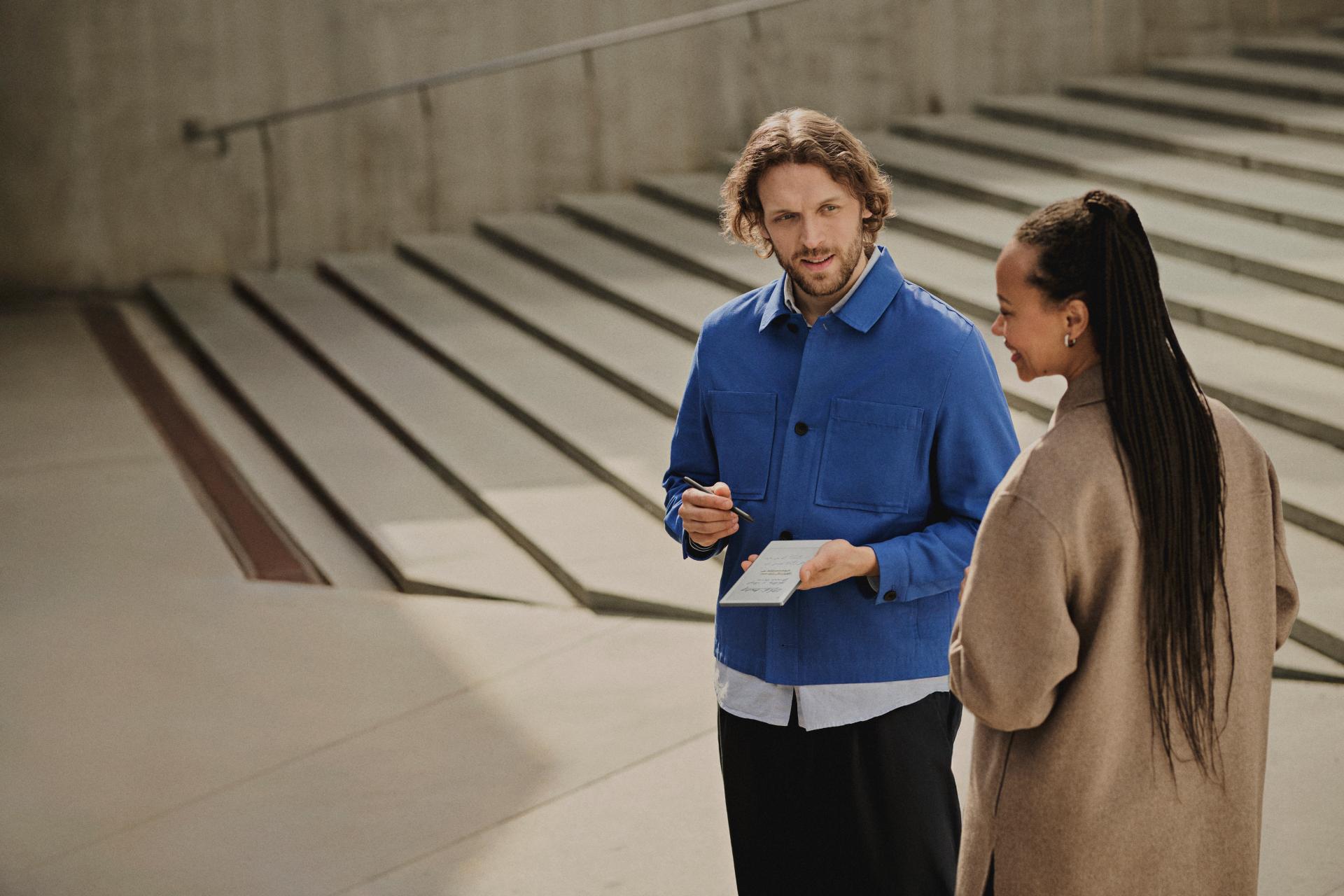 Two people stand near steps.
