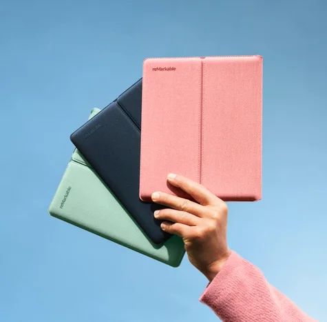 Hand holding up three different colors of the sleeve folio for reMarkable Paper Pure