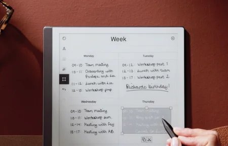 A reMarkable paper tablet showing a weekly planner, with a hand pasting a copied area.