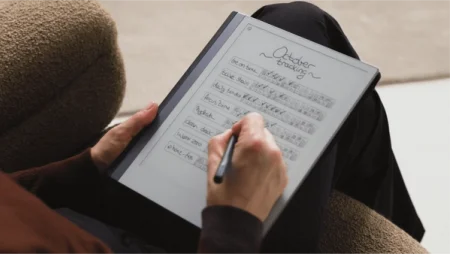 A reMarkable paper tablet showing a person writing with the Marker on an October tracking sheet.