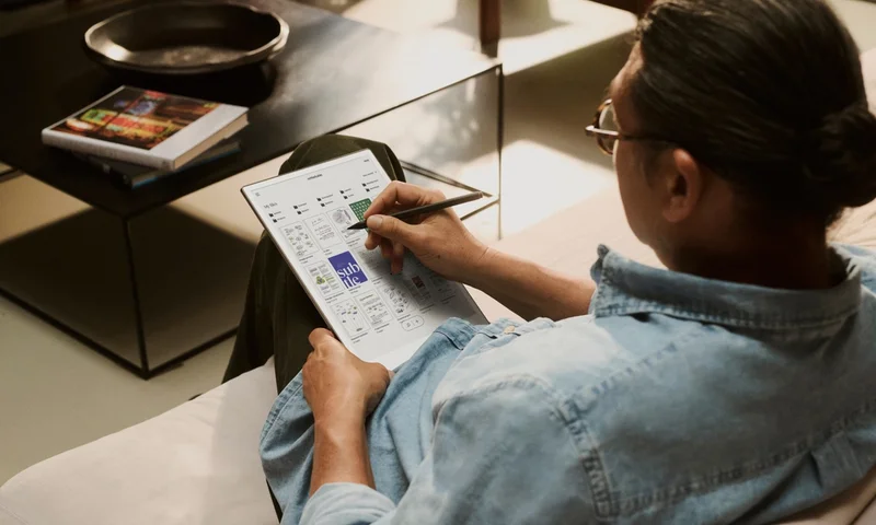 A person in a couch using a reMarkable paper tablet to write with Marker Plus.