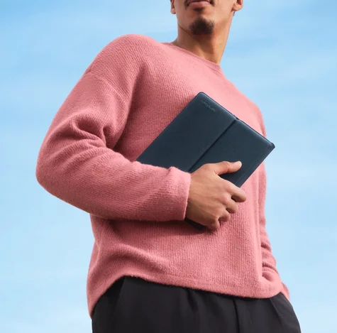Man wearing a pink sweather holding a sleeve folio tight