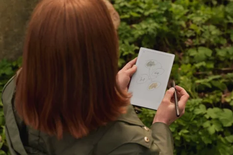 A woman in a natural environment, sketching on a reMarkable Paper Pro Move