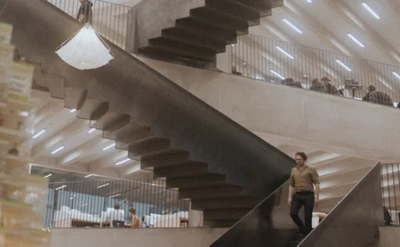 Architect Jakob Lange walking down an interior staircase.