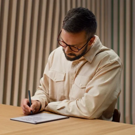 A person writing on the reMarkable paper tablet with the Marker.
