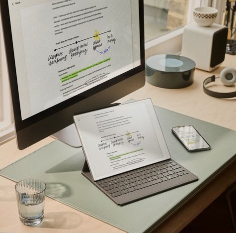 A reMarkable Paper Pro, iPhone and Mac together on a desk showing syncing of content between devices.