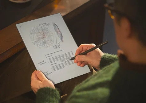 Over-the-shoulder view of a person using a marker plus to write handwritten notes and sketch diagrams on reMarkable Paper Pro.