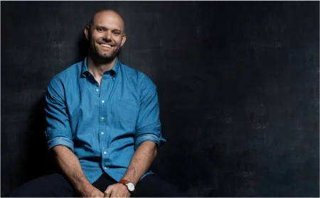 Author James Clear smiling and wearing a blue shirt.