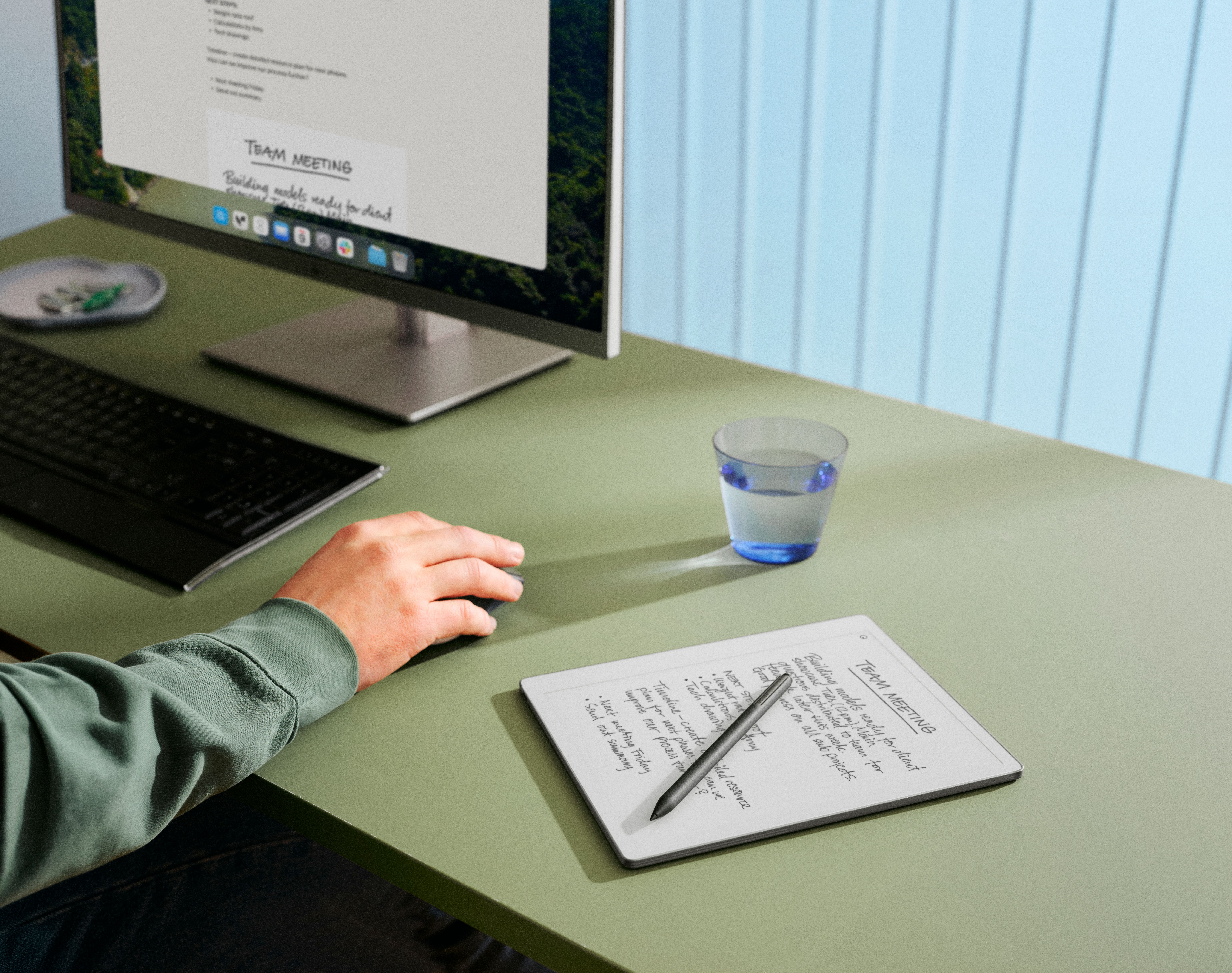 A reMarkable Paper Pro Move with Marker Plus laying on a coffee table next to a laptop and phone, all displaying the same synced content.