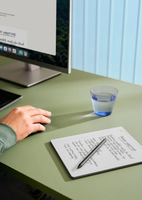 A reMarkable Paper Pro Move with Marker Plus laying on a coffee table next to a laptop and phone, all displaying the same synced content.