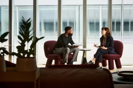 Two colleagues discussing something in an office environment