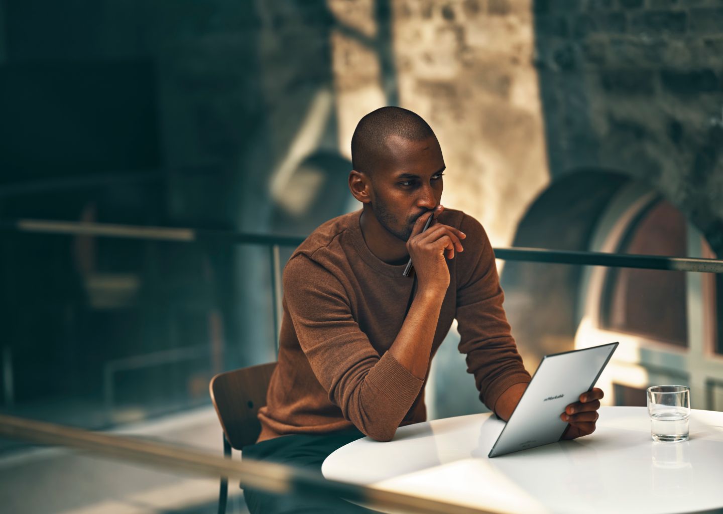 Man sitting at table with a reMarkable paper tablet