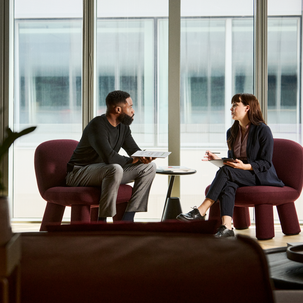 Two colleagues talking in the office, both using a reMarkable Paper Pro to stay in the present
