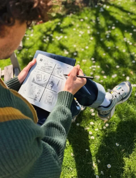 Jack Ogden sitting outside on a bench drawing a storyboard on his reMarkable Paper Pure tablet.