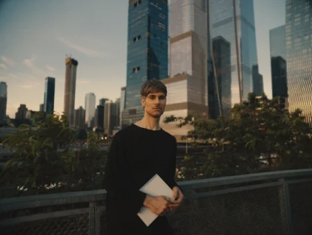 Matthew holding a reMarkable paper tablet against a cityscape backdrop.