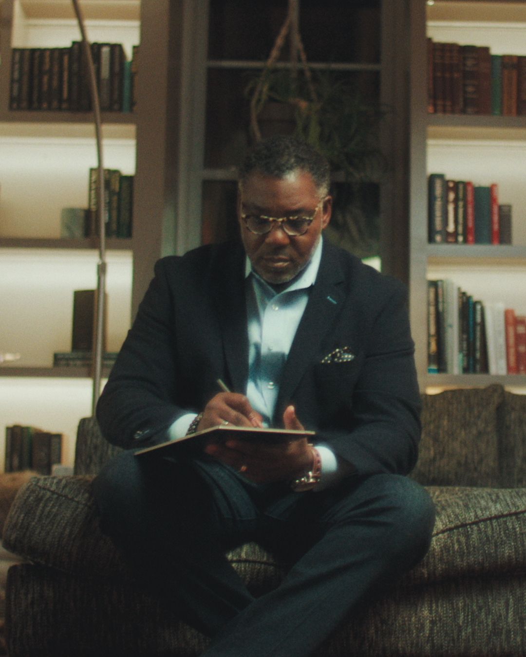 Dr. Adrian Haugabrook sitting and writing on the reMarkable paper tablet.