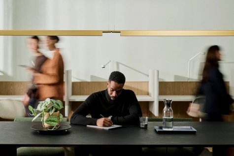A man, focused, using his reMarkable Paper Pro in a busy office environment.