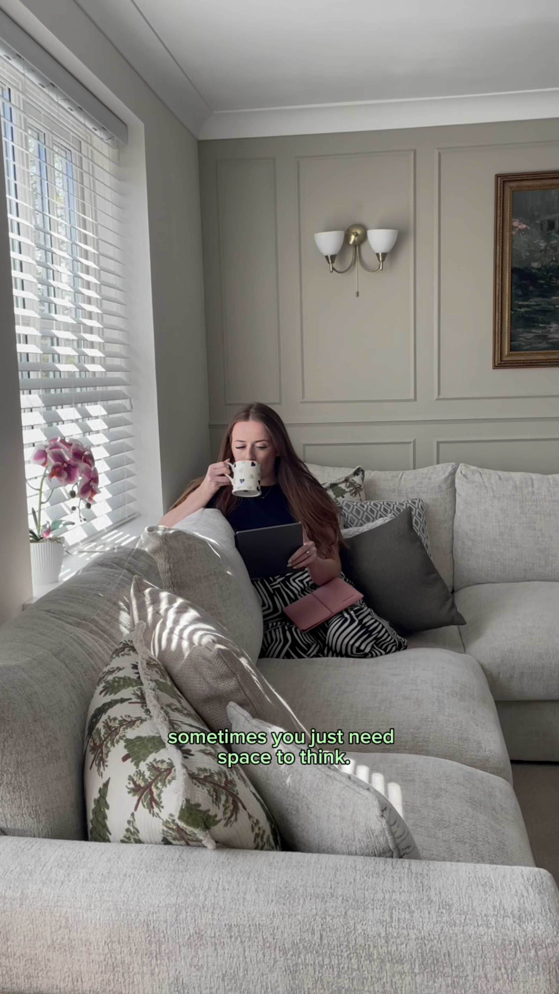 Mia Siddique sitting in her sofa drinking a cup of tea while reading on her reMarkable Paper Pure tablet.